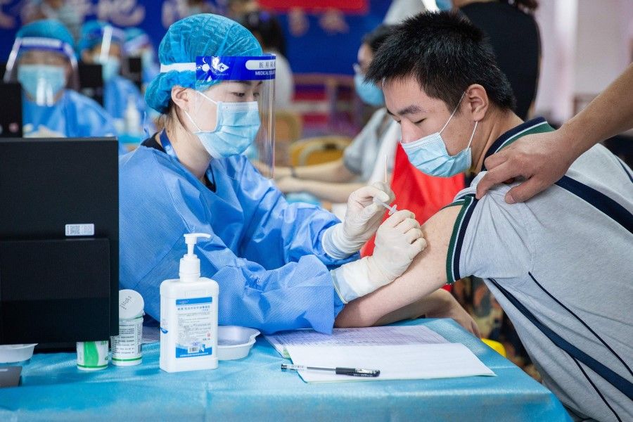 This photo taken on 21 August 2021 shows a high school student receiving the Sinovac Covid-19 vaccine in Nanjing in China's eastern Jiangsu province. (STR/AFP)