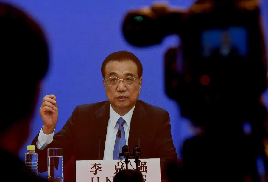 Chinese Premier Li Keqiang is seen on a screen during a press conference held via online video link following the National People's Congress at the Great Hall of the People in Beijing, 28 May 2020. (Noel Celis/AFP)