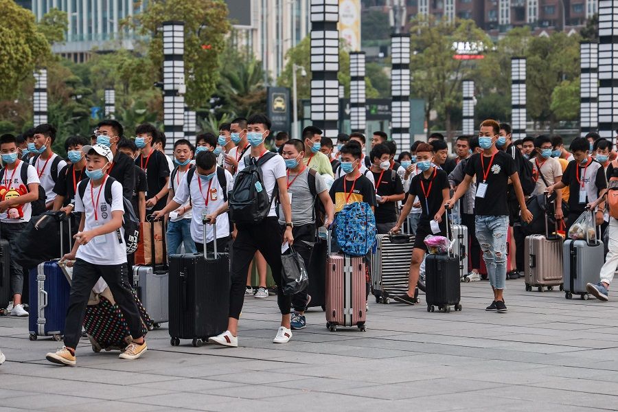 Technical school students arrive at Chongqing North Railway Station as they leave for their internship on the first day of the new semester in Chongqing, China, 1 September 2020. (STR/AFP)