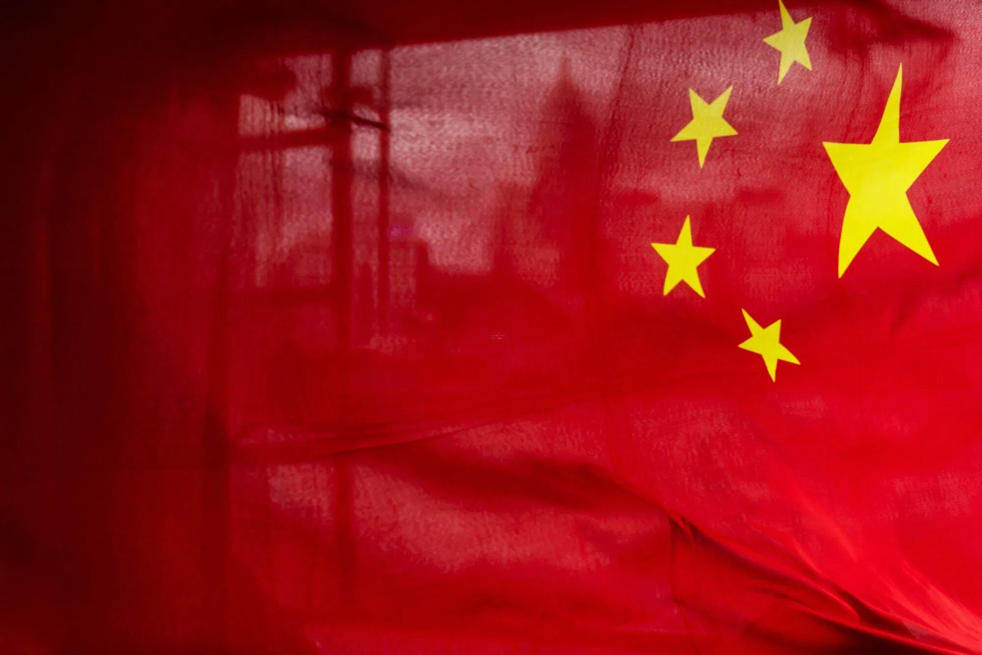An attendee waves the flag of China during an event aboard a Star Ferry to celebrate the 27th anniversary of Hong Kong’s return to Chinese rule in Hong Kong, China, on 1 July 2024. (Paul Yeung/Bloomberg)