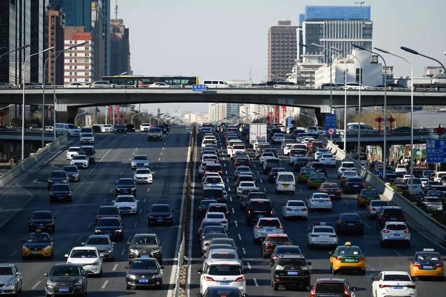 Vehicles drive along a street at Central Business District (CBD) in Beijing on 16 January 2023. (Wang Zhao/AFP)