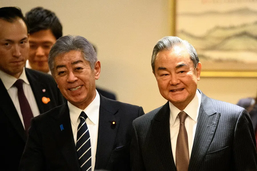 Japanese Foreign Minister Takeshi Iwaya and Chinese Foreign Minister Wang Yi smile before the Japan-China high-level economic dialogue in Tokyo on 22 March 2025. (Philip Fong/Reuters)