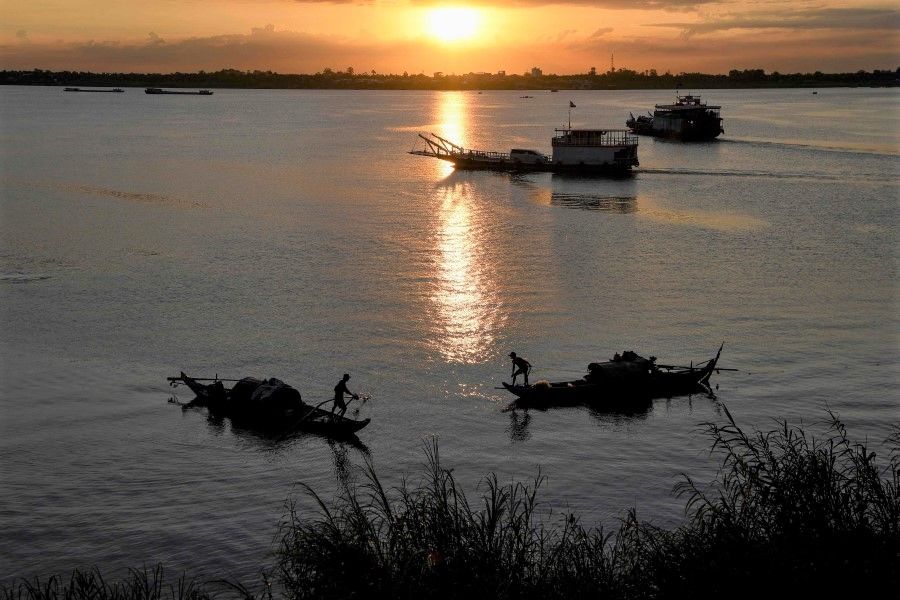 Fishermen pull in their fishing nets as the sun rises over the Mekong river in Phnom Penh on 9 June 2020. (Tang Chhin Sothy/AFP)
