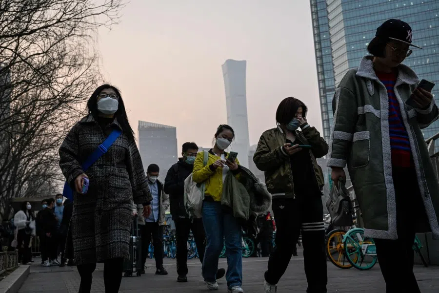 People commute in the central business district during rush hour in Beijing on 7 March 2023. (Jade Gao/AFP)
