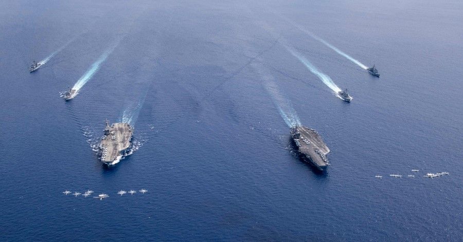 This US Navy photo released 7 July 2020 shows US aircraft in formation over aircraft carriers USS Nimitz and USS Ronald Reagan as their carrier strike groups are conducting dual carrier operations in the Indo-Pacific on 6 July 2020. (Keenan Daniels/US NAVY/AFP)