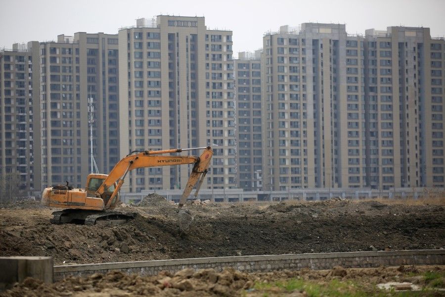 An excavator is seen at a construction site of new residential buildings in Shanghai, China, in this 21 March 2016 file photo. (Aly Song/Reuters)