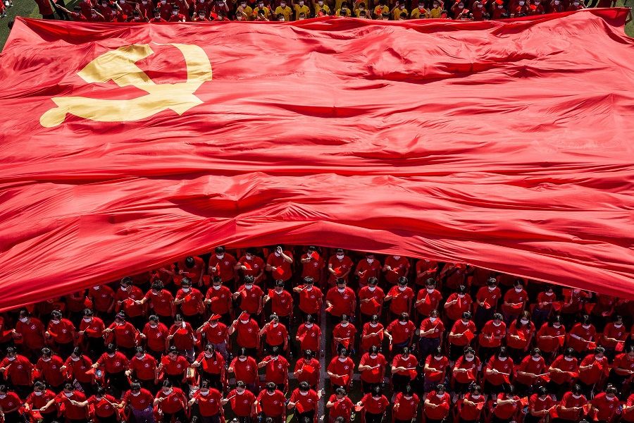 University students display a flag of the Communist Party of China to mark the party's 100th anniversary during an opening ceremony of the new semester in Wuhan, Hubei province, China, on 10 September 2021. (STR/AFP)