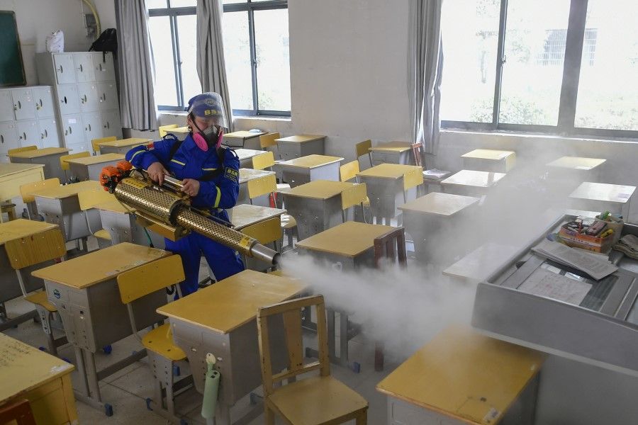 A volunteer disinfects a classroom in a secondary school in Hubei, in preparation for classes resuming. (Tang Jun/Xinhua)