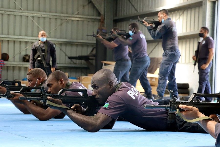 An undated handout photo released on 29 March 2022 by the Royal Solomon Islands Police Force (RSIPF) shows China Police Liason Team officers training local RSIPF officers. (Handout/RSIPF/AFP)