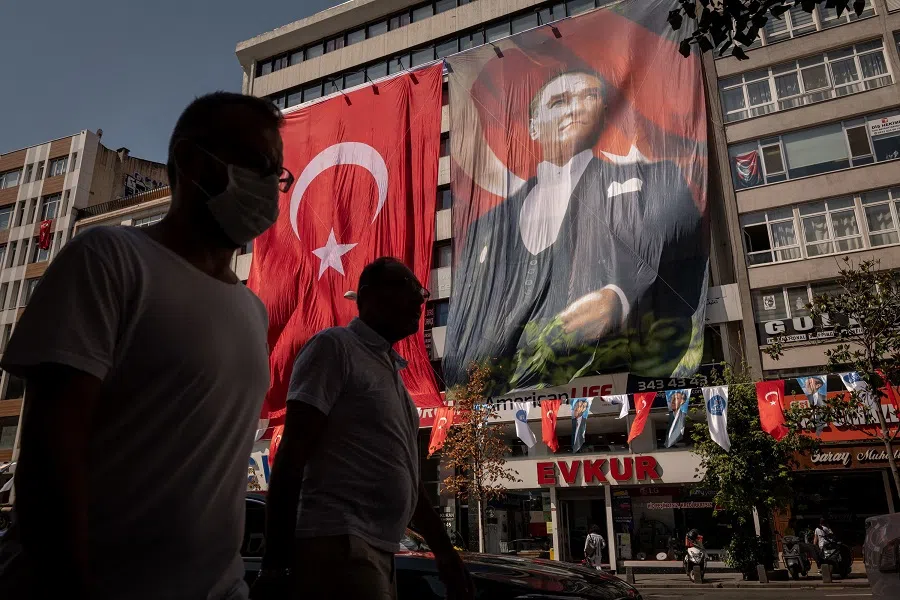 A Turkish national flag (left) and a banner bearing the portrait of Mustafa Kemal Ataturk, founder of the modern Turkish republic, hang from the exterior of a building in the Sisli district of Istanbul, Turkey, on 29 August 2022. (Nicole Tung/Bloomberg)