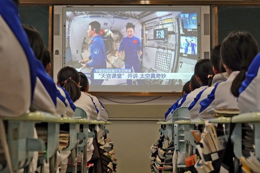 Students watch a live image of a lesson by Chinese astronauts from China's Tiangong space station, at a school in Yantai in China's eastern Shandong province on 9 December 2021. (AFP)