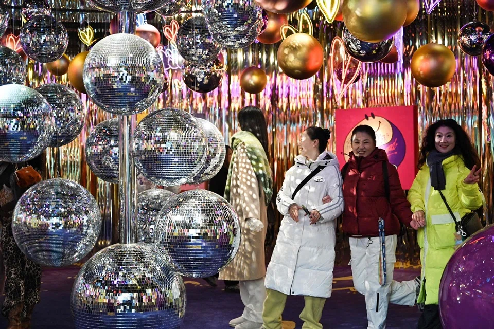 People visit an installation outside a shopping centre in Beijing on 24 December 2024. (Adek Berry/AFP)
