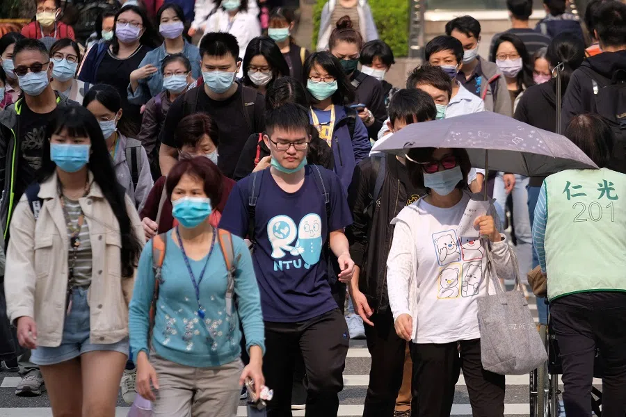 This photo taken on 31 March 2021 shows people crossing a street in Taipei, Taiwan. (Sam Yeh/AFP)