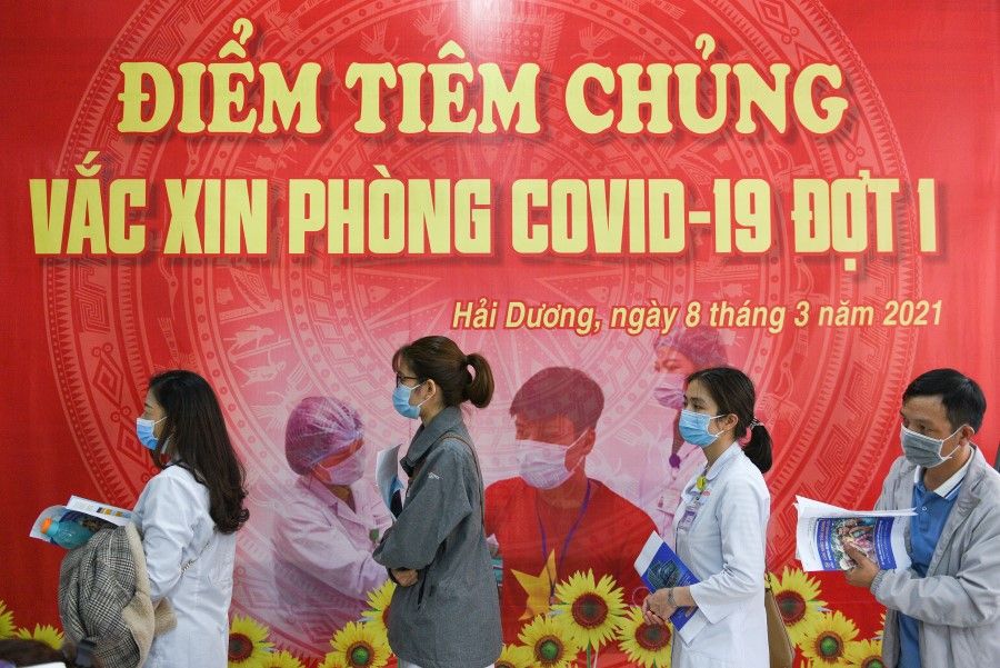 Health workers wait for their turn as Vietnam starts its official rollout of AstraZeneca's Covid-19 vaccine for health workers, at Hai Duong Hospital for Tropical Diseases, Hai Duong province, Vietnam, 8 March 2021. (Thanh Hue/Reuters)