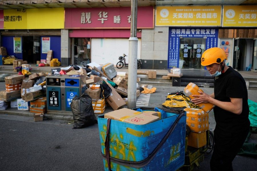 A delivery worker sorts parcels at a makeshift logistics station ahead of Alibaba's Singles' Day shopping festival, following the coronavirus disease (Covid-19) outbreak in Shanghai, China, 10 November 2022. (Aly Song/Reuters)