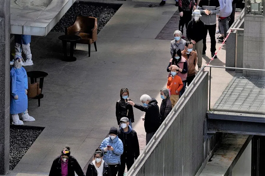 Residents line up for nucleic acid testing at a residential area, during the second stage of a two-stage lockdown to curb the spread of Covid-19, in Shanghai, China, 4 April 2022. (Aly Song/Reuters)