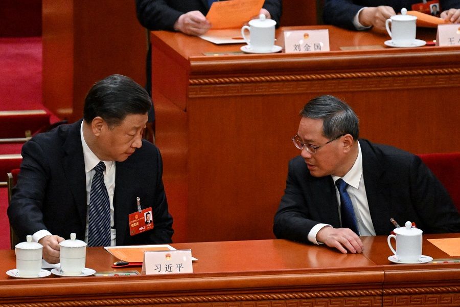 China's President Xi Jinping (left) speaks with Premier Li Qiang during the fifth plenary session of the National People's Congress (NPC) at the Great Hall of the People in Beijing, China, on 12 March 2023. (Noel Celis/AFP)