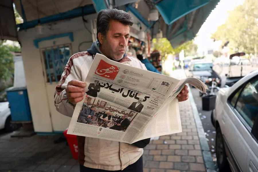 An Iranian man reads a copy of the Ham Mihan daily newspaper with the front page main headline highlighting a reported meeting between Tehran’s ambassador to the United Nations and tech billionaire Elon Musk in New York, outside a news stand in Tehran on 16 November 2024. (AFP)