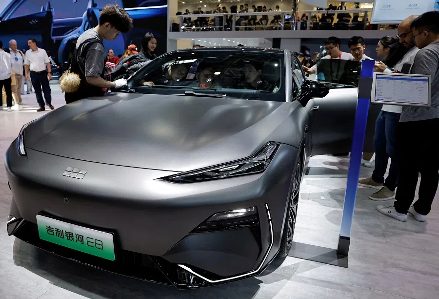 A staff member cleans the Geely Galaxy E8 electric vehicle at the Beijing International Automotive Exhibition, or Auto China 2024, in Beijing, China, on 25 April 2024. (Tingshu Wang/Reuters)