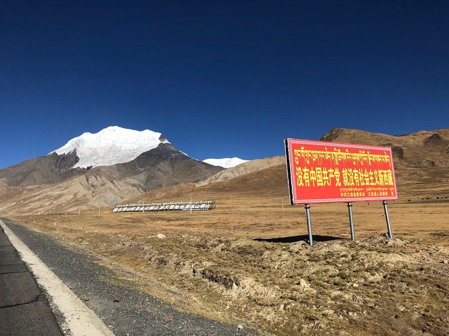 A Chinese Communist Party slogan billboard along a road in Tibet. It reads: "There will be no socialist Tibet without the CCP."