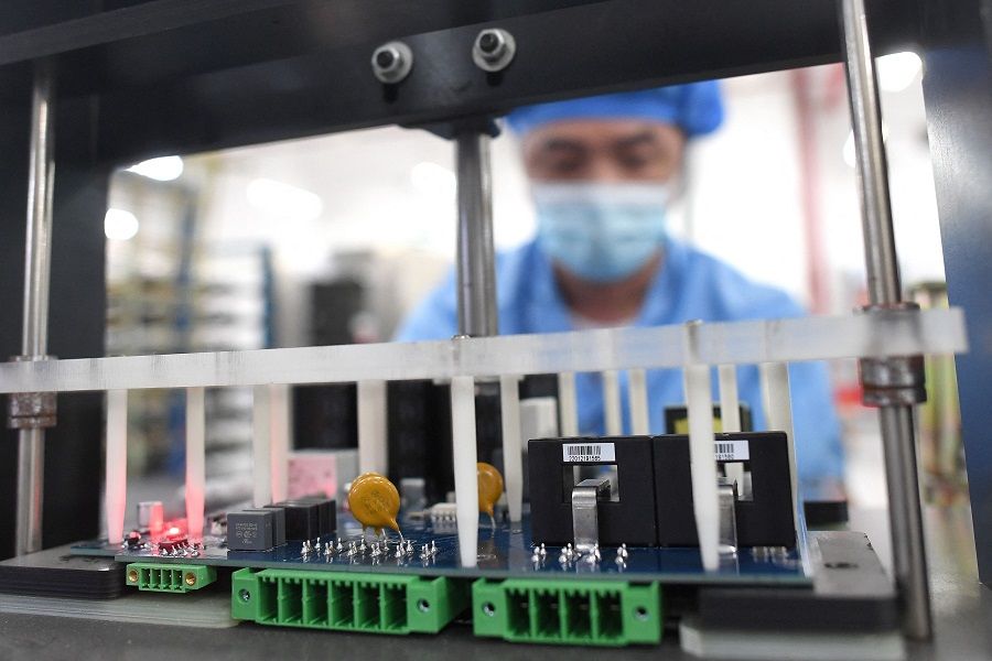 A worker is seen producing industrial robots at a factory in Wuhan, Hubei province, China, 13 April 2022. (AFP)
