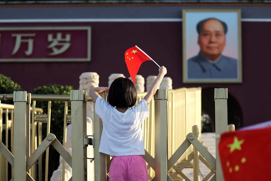 A child holds a flag in front of the portrait of late Chinese Chairman Mao Zedong on the Tiananmen Gate, in Beijing, China, on 12 June 2024.