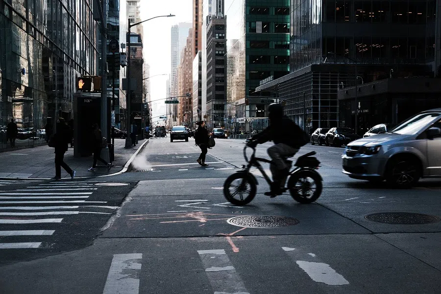 People walk through Manhattan as office buildings, which make up the heart of midtown Manhattan, stand largely empty on 4 March 2021 in New York City. (Spencer Platt/Getty Images/AFP)