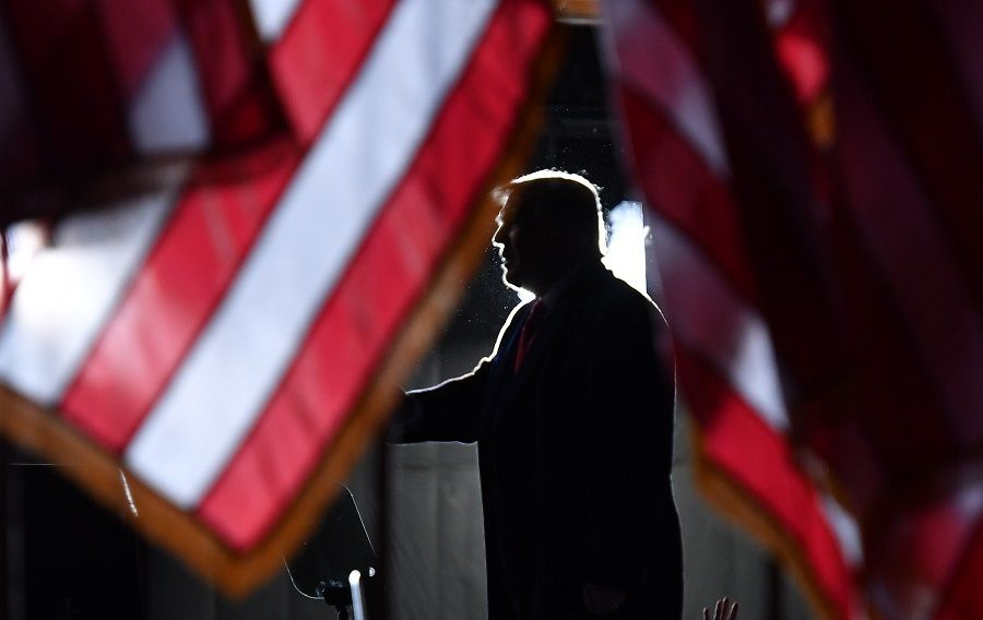 US President Donald Trump is seen behind US flags as he speaks to supporters at a "Great American Comeback" event at Central Wisconsin Airport in Mosinee, Wisconsin, on 17 September 2020. (Mandel Ngan/AFP)