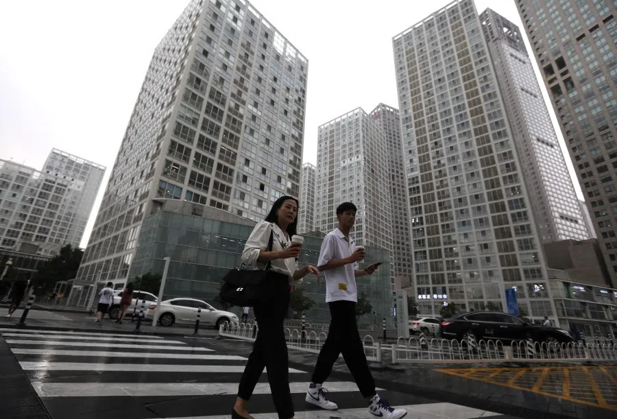 People walk past an office compound in Beijing's Central Business District (CBD), China, 13 July 2021. (Tingshu Wang/Reuters)