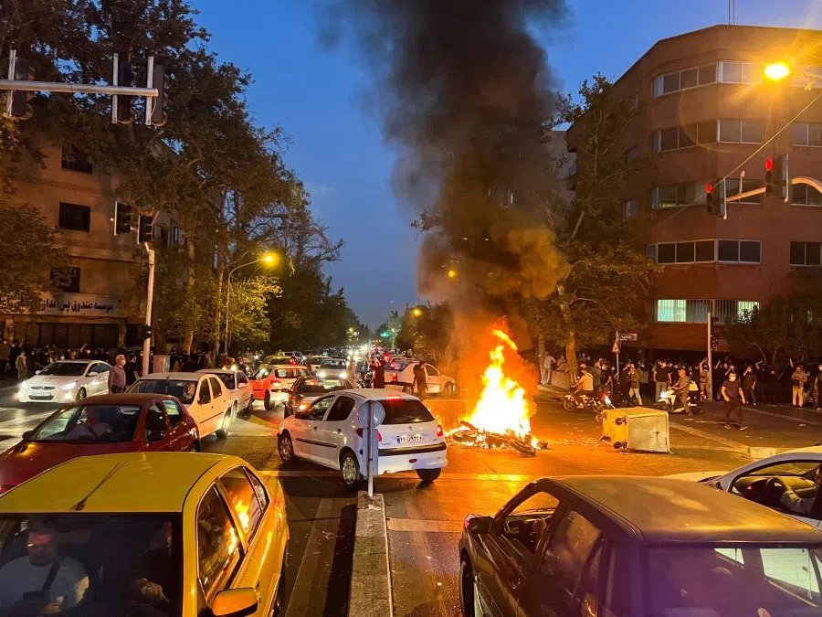 A police motorcycle burns during a protest over the death of Mahsa Amini, a woman who died after being arrested by the Islamic republic's "morality police", in Tehran, Iran, 19 September 2022. (West Asia News Agency via Reuters)