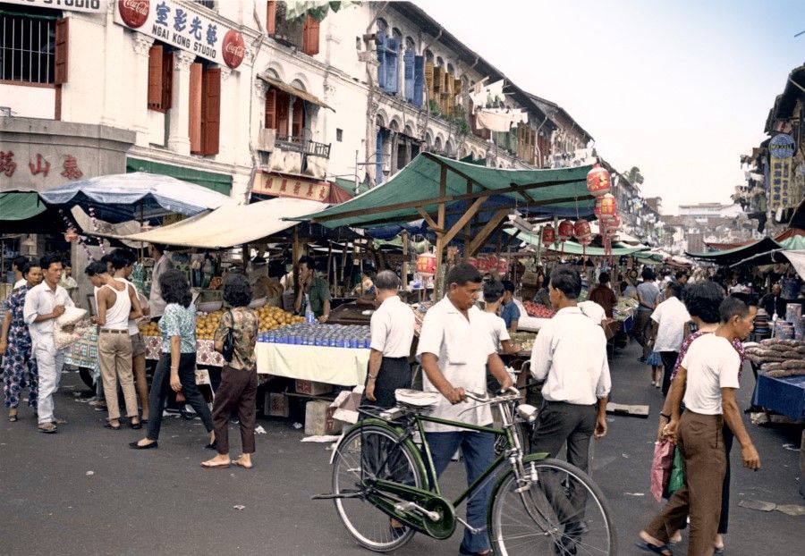 A bustling market in Singapore in the 1960s, with all kinds of fruits, vegetables, and foodstuffs. Women regularly went to the market to select the ingredients they would use to prepare meals at home.