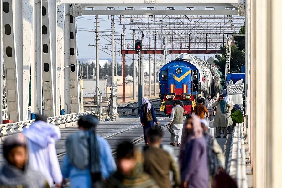Afghan men gather as a fuel cargo train departs from Afghanistan, at the Afghanistan-Uzbekistan Friendship Bridge in the border town of Hairatan, Balkh province, on 23 June 2025.