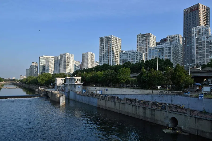 High-rise buildings are seen along a canal in Beijing on 17 June 2025.