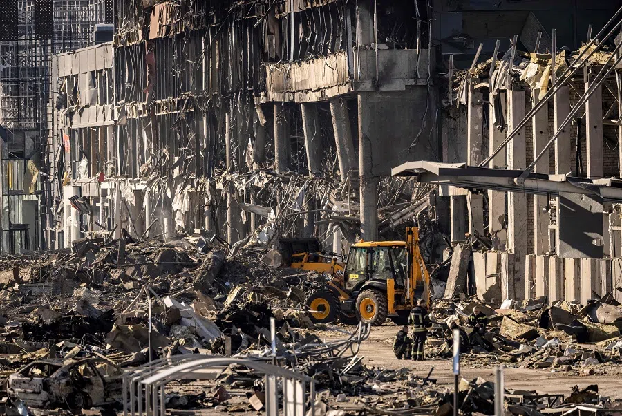 Ukrainian firefighters work amid the rubble of the Retroville shopping mall, a day after it was shelled by Russian forces in a residential district in Kyiv, Ukraine, on 21 March 2022. (Fadel Senna/AFP)