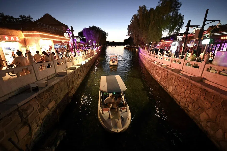 People ride on boats at Houhai in Beijing, China, on 15 August 2022. (Noel Celis/AFP)