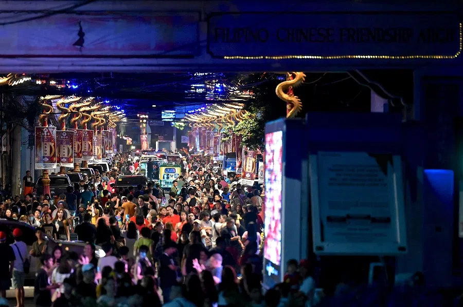 People walk in the Chinatown section of Manila on 9 February 2024. 