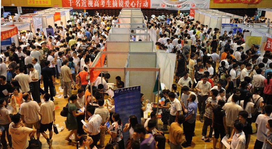 Chinese parents and their children gather at an education fair in Hefei, eastern China's Anhui province, as they search for suitable colleges for further education on June 27, 2009. (AFP)