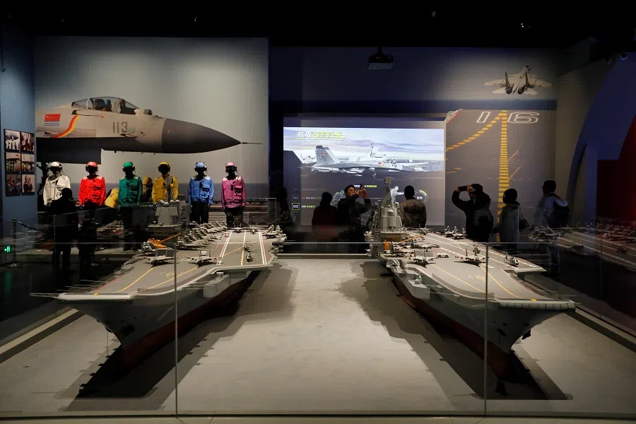 Visitors look at replicas of aircraft carriers Liaoning and Shandong, displayed at the PLA Naval Museum on the 75th founding anniversary of the PLAN, in Qingdao, Shandong province, China, on 23 April 2024. (Florence Lo/Reuters)