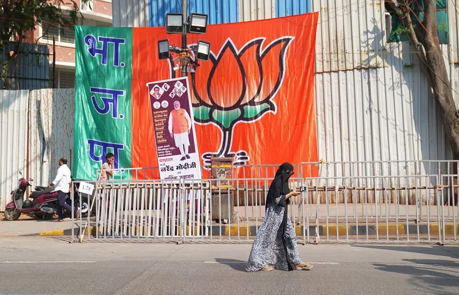 A pedestrian walks past a flag during a campaign rally of Narendra Modi, India’s prime minister (not pictured), in Mumbai, India, on 15 May 2024. (Indranil Aditya/Bloomberg)