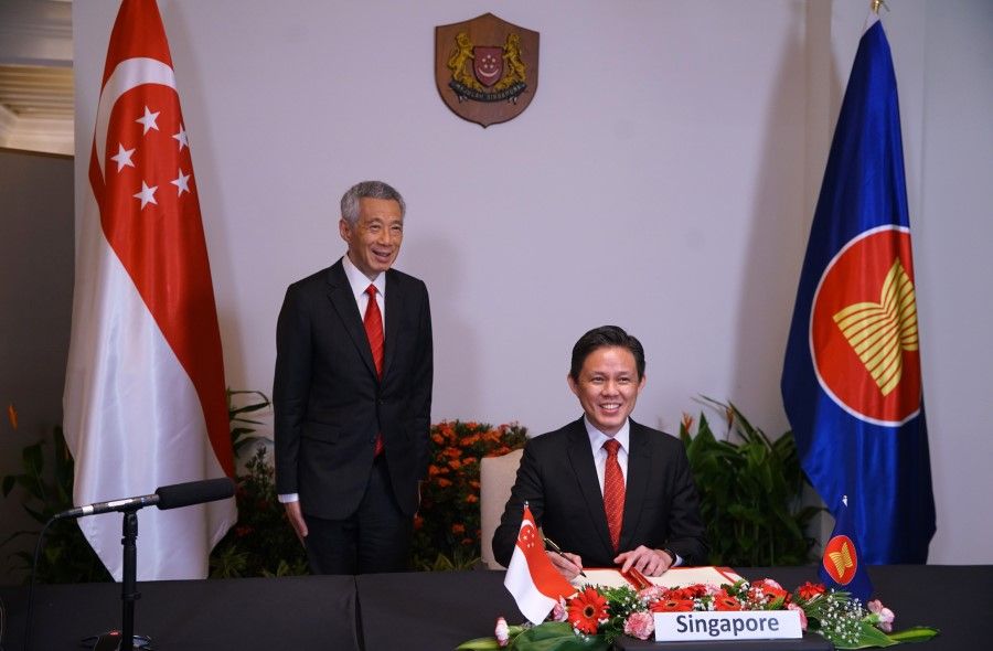 Minister for Trade and Industry Chan Chun Sing (seated) signed the Regional Comprehensive Economic Partnership (RCEP) free trade agreement (FTA) in the presence of Prime Minister Lee Hsien Loong on 15 November 2020. The pact takes effect once ratified by six of the 10 Asean countries, as well as three of their five non-Asean trade partners. (SPH Media)