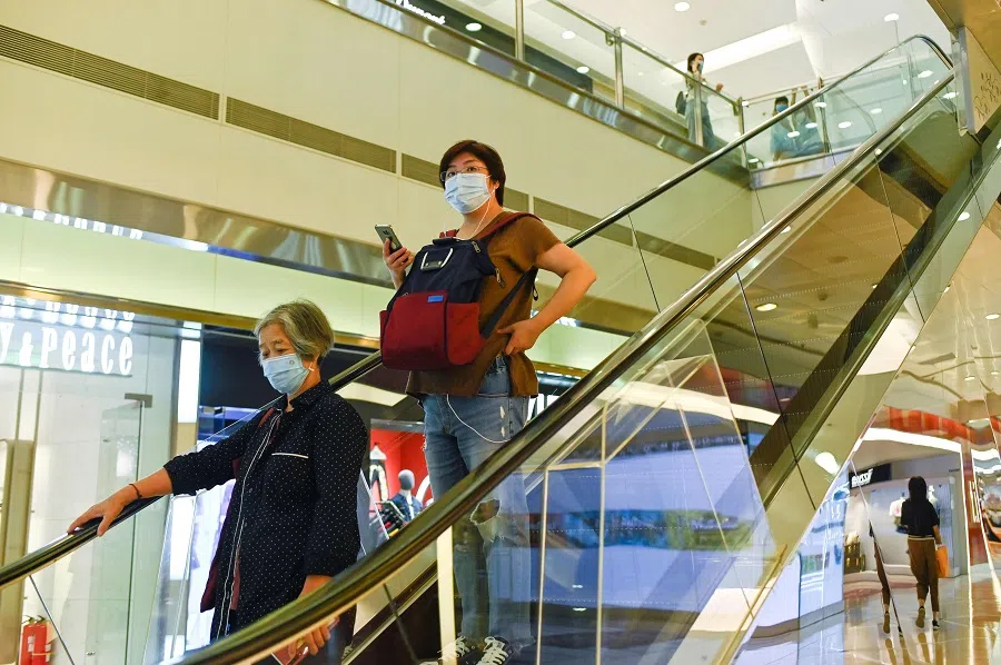 People wearing face masks visit a mall in Beijing on 14 August 2020. (Wang Zhao/AFP)