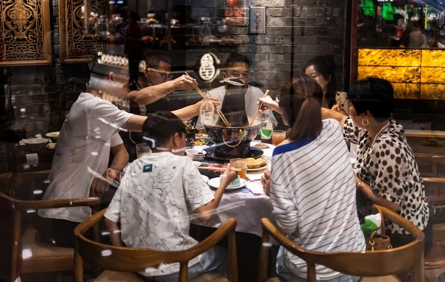 Diners share a meal around a Chinese hot pot table at a traditional restaurant in Beijing, China, on 8 July 2026.