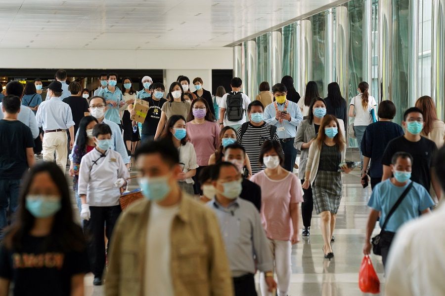 People wearing face masks following the Covid-19 outbreak walk at a shopping mall in Hong Kong on 20 July 2020. (Lam Yik/Reuters)