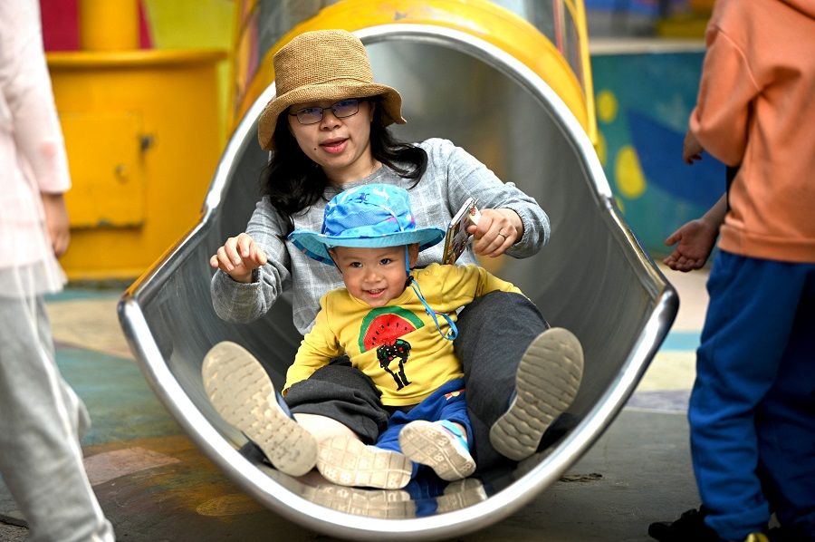 A mother and her baby play on a slide at Wukesong shopping district in Beijing, China on 11 May 2021. (Noel Celis/AFP)