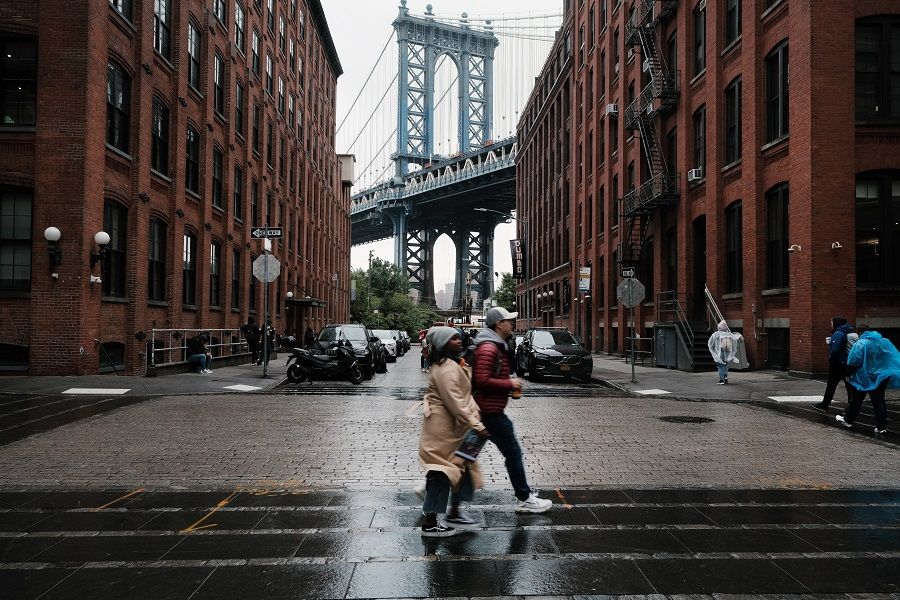 People walk through the rain in Brooklyn on 4 October 2022 in New York City, US. (Spencer Platt/Getty Images/AFP)