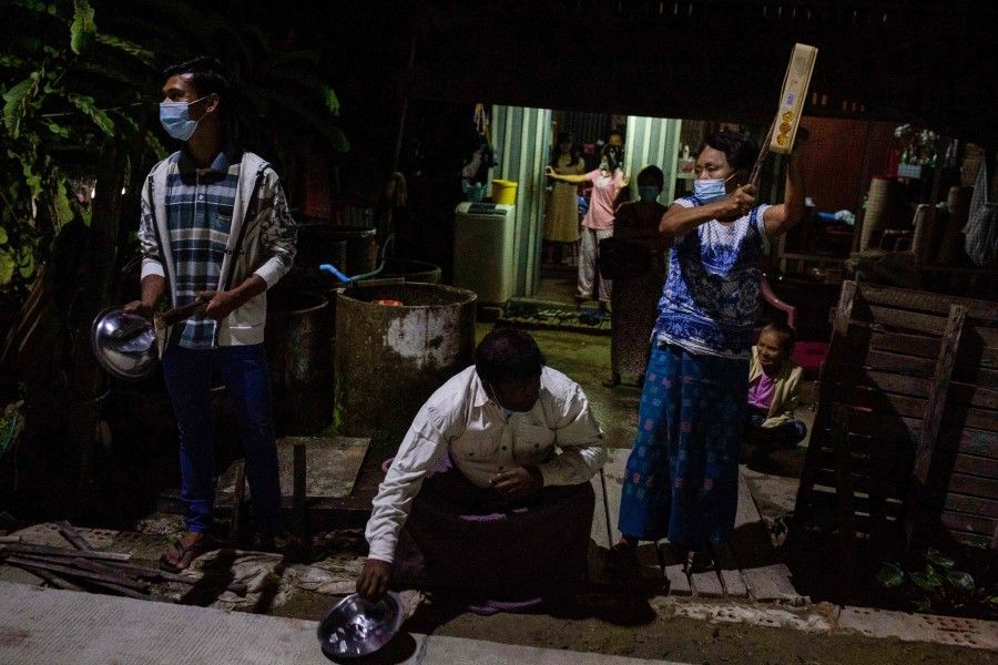 People clatter tins and pans to make noise to protest the military coup in response to a social media campaign in Yangon on 2 February 2021, as the party of Myanmar's toppled leader Aung San Suu Kyi demanded her immediate release Tuesday. (STR/AFP)