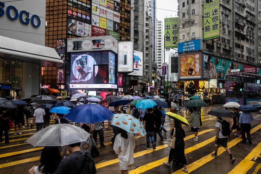People use umbrellas to protect themselves from the rain in Hong Kong, China, on 16 June 2023 (Isaac Lawrence/AFP)