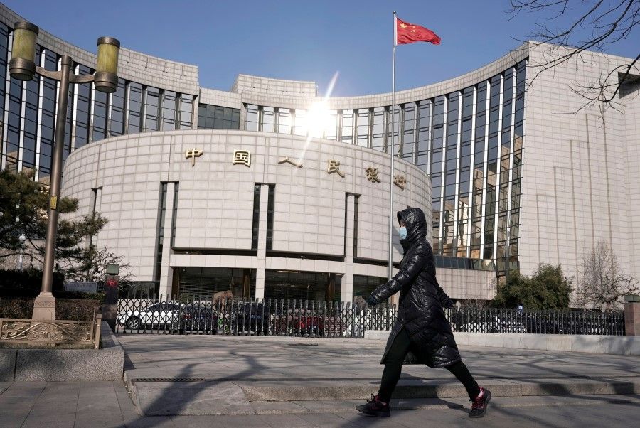 A woman walks past the headquarters of the People's Bank of China in Beijing. The PBOC is introducing measures to help businesses. (Jason Lee/REUTERS)