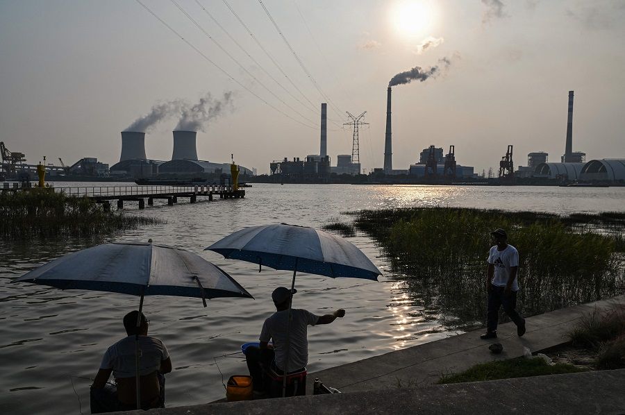 Anglers fish along the Huangpu river across the Wujing Coal-Electricity Power Station in Shanghai, China, on 28 September 2021. (Hector Retamal/AFP)