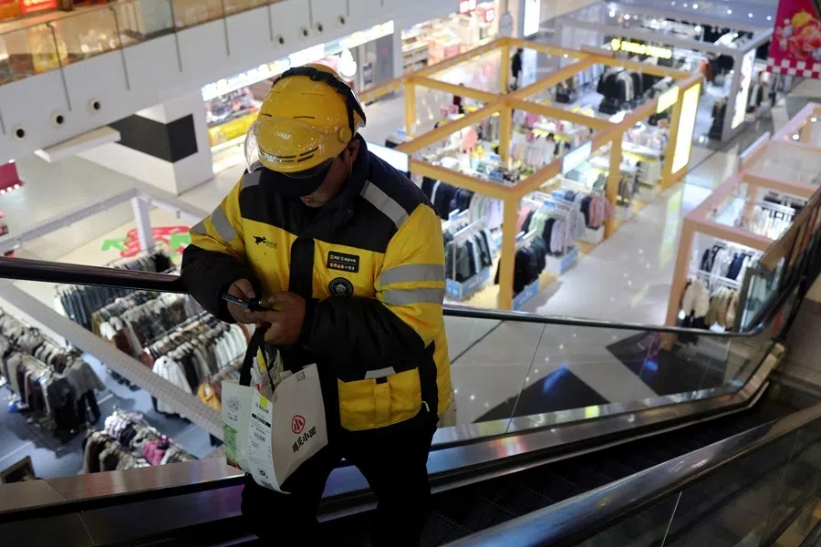 A Meituan delivery worker picks up a food order at a shopping mall in Beijing, China, on 17 October 2024.